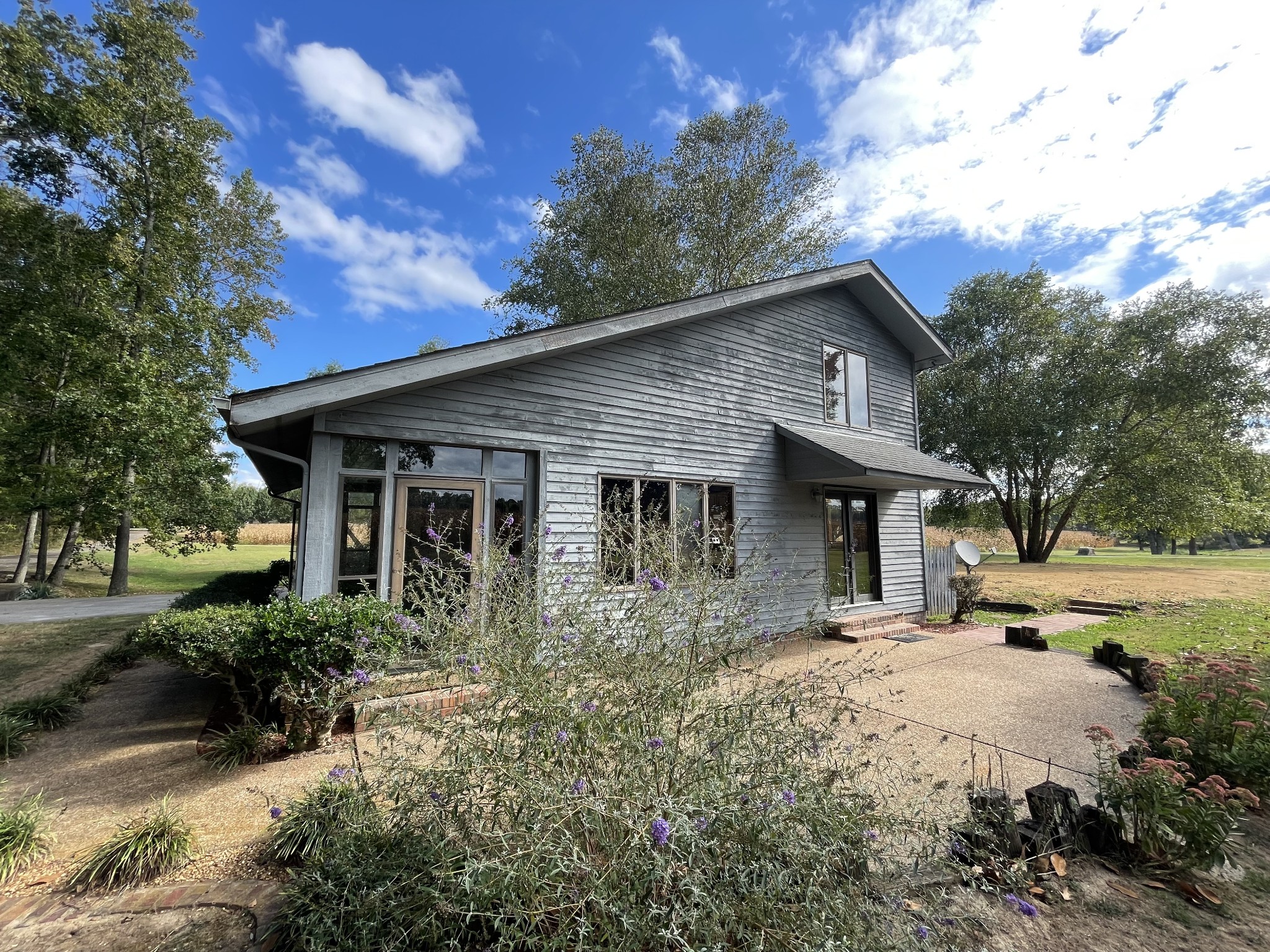 a front view of house with yard and trees around