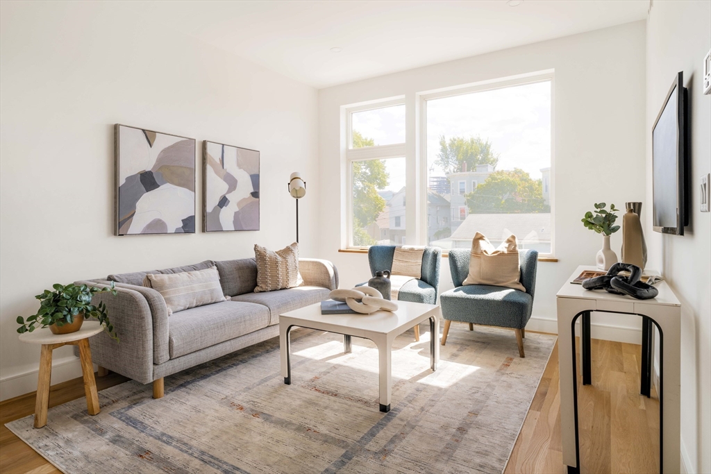 a living room with furniture a large window and a flat screen tv