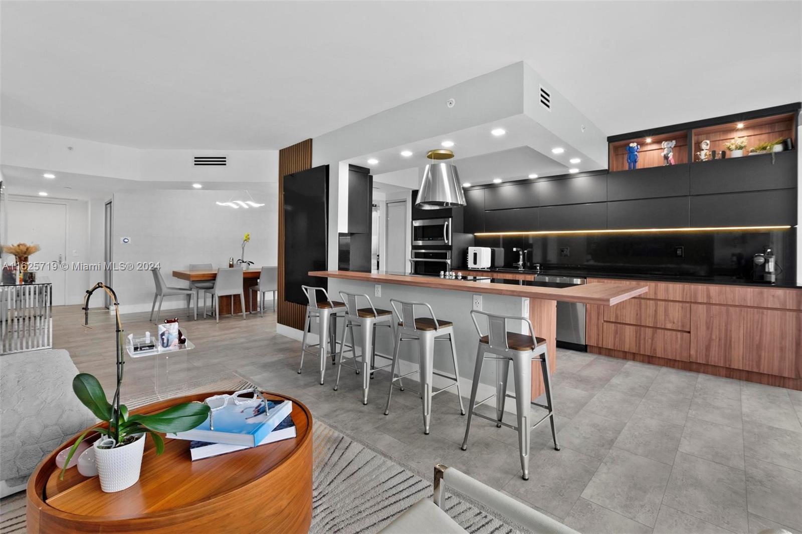 a living room with furniture kitchen view and a large mirror