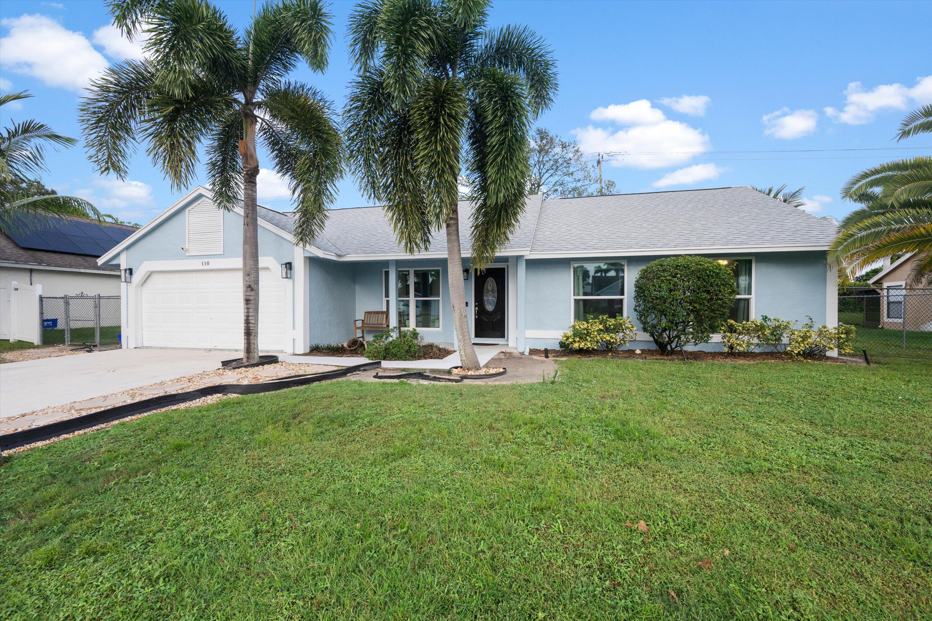 a front view of a house with a garden and patio