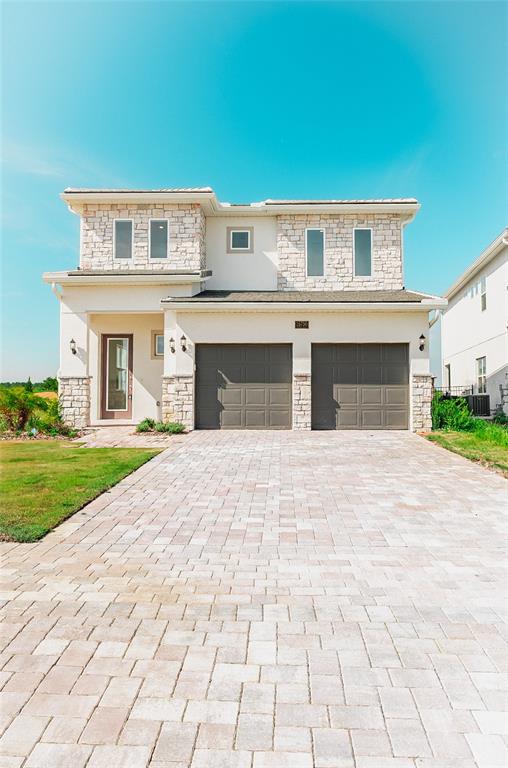 a front view of a house with a yard and garage