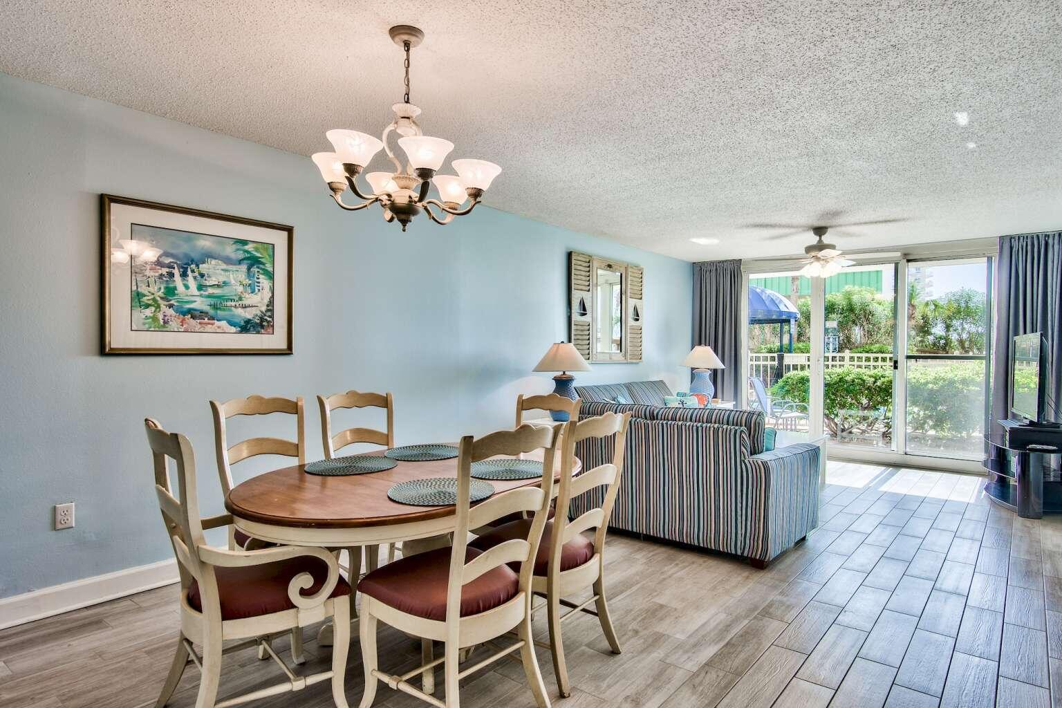 a dining room with furniture a large window and wooden floor