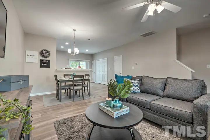 a living room with furniture kitchen and a chandelier