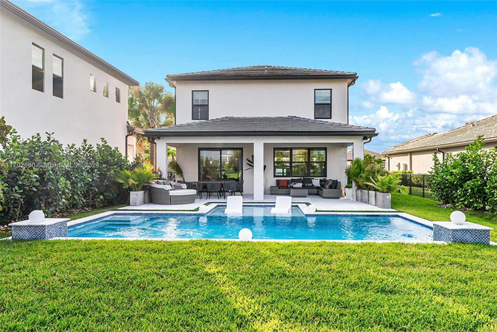 a view of house with swimming pool and outdoor seating