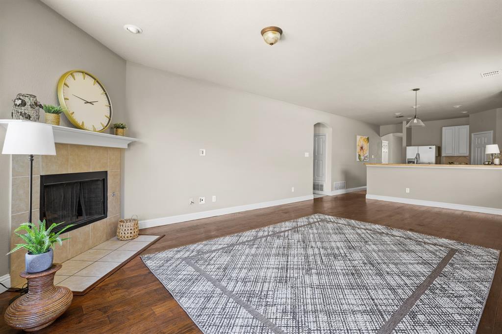 a view of an empty room and kitchen with fireplace window