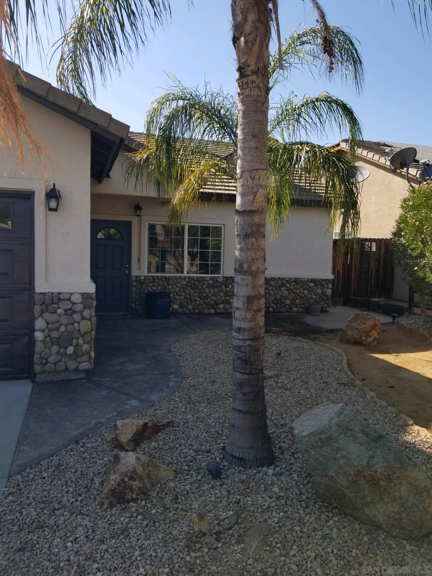 a front view of a house with plants