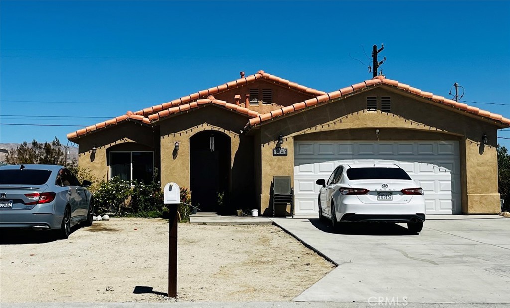 a front view of a house with cars parked