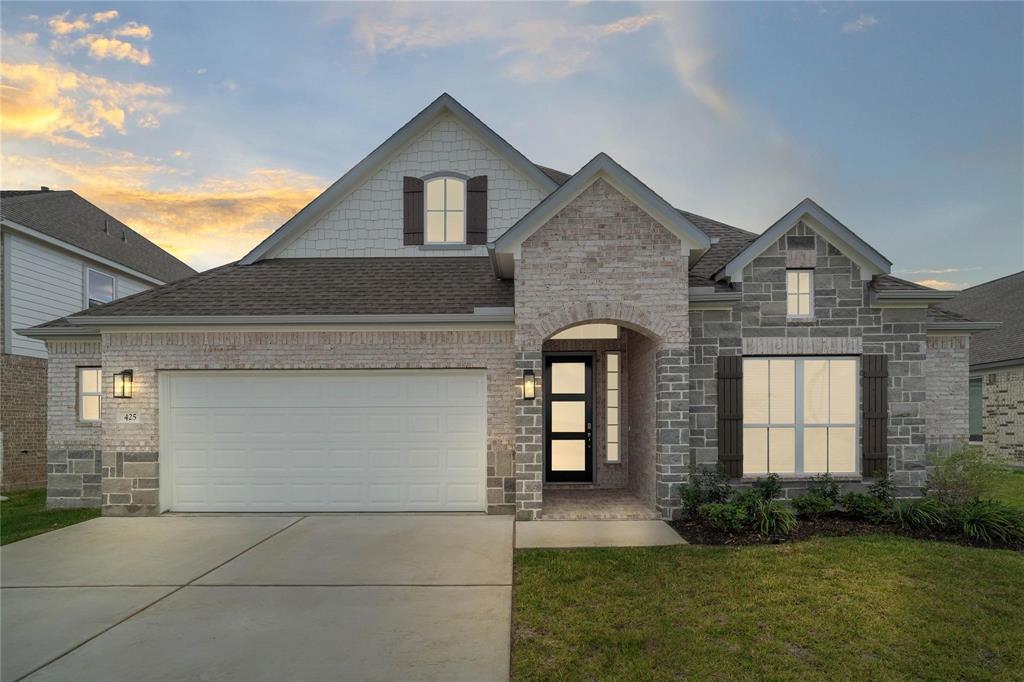 a front view of a house with a yard and garage