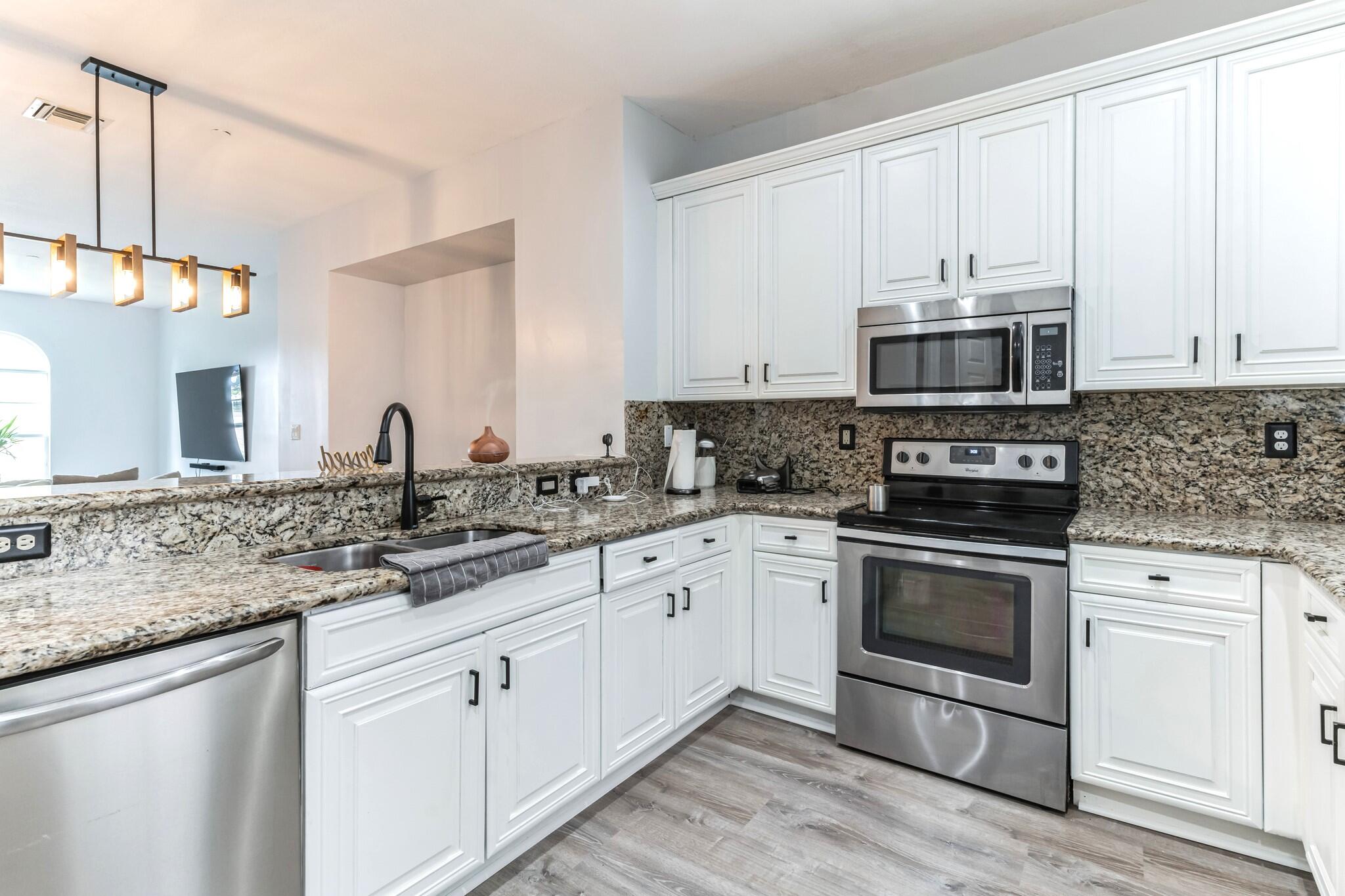 a kitchen with stainless steel appliances granite countertop a sink and a stove