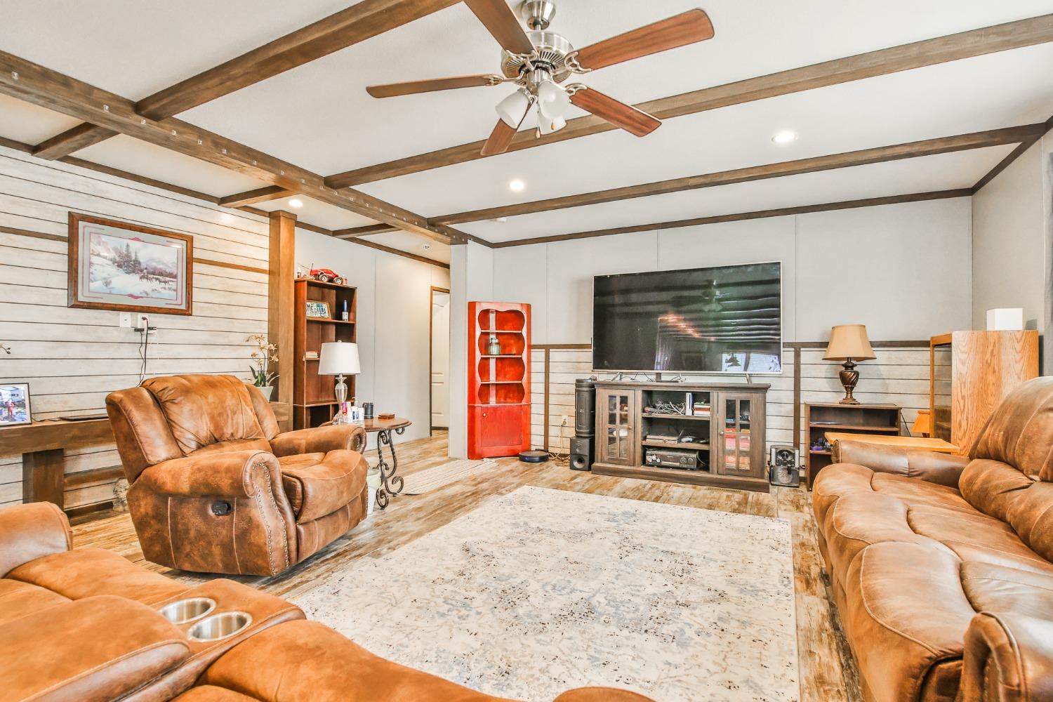 a living room with furniture a flat screen tv and a large window