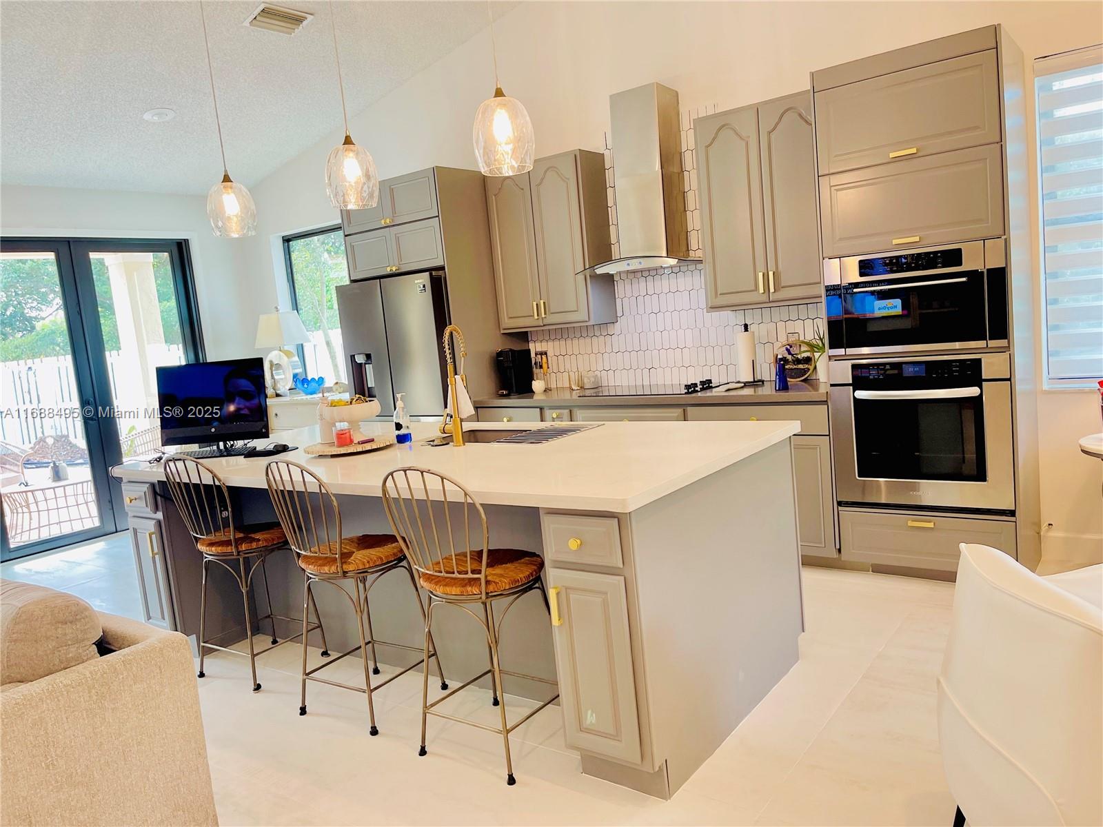 a kitchen with stainless steel appliances a stove a sink dishwasher and a refrigerator with wooden floor