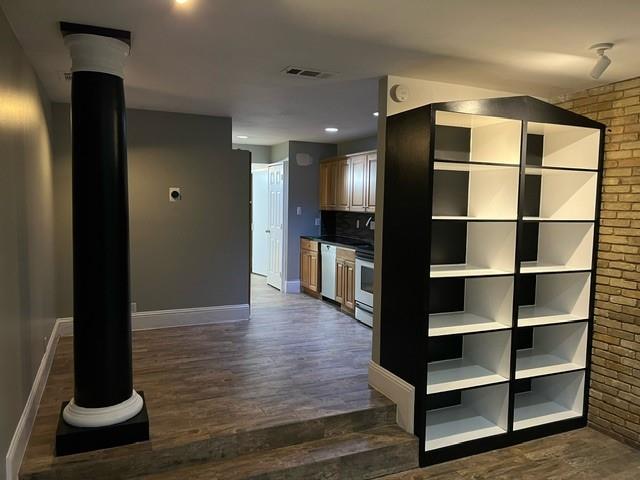 a view of a hallway with wooden floor and cabinet