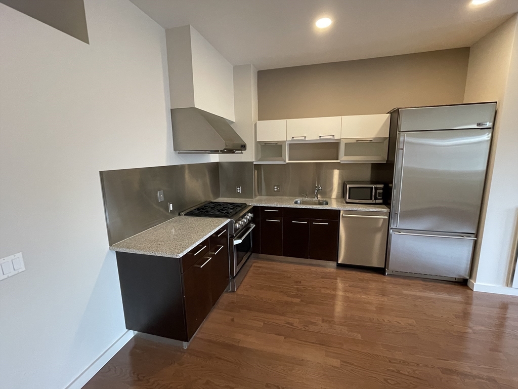 a kitchen with granite countertop a refrigerator and a sink