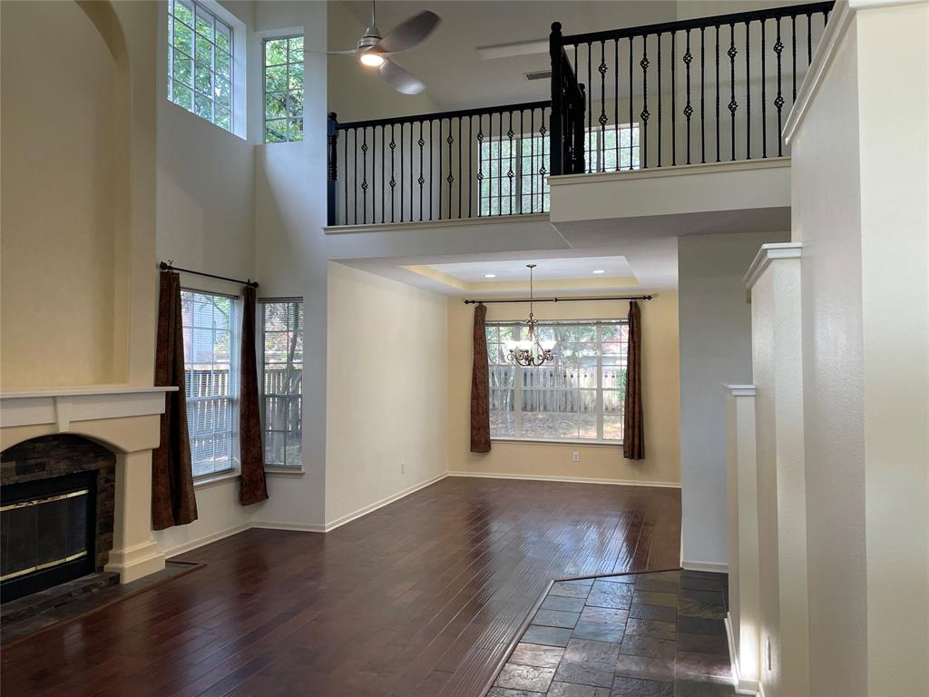 an entryway with wooden floor fireplace and windows