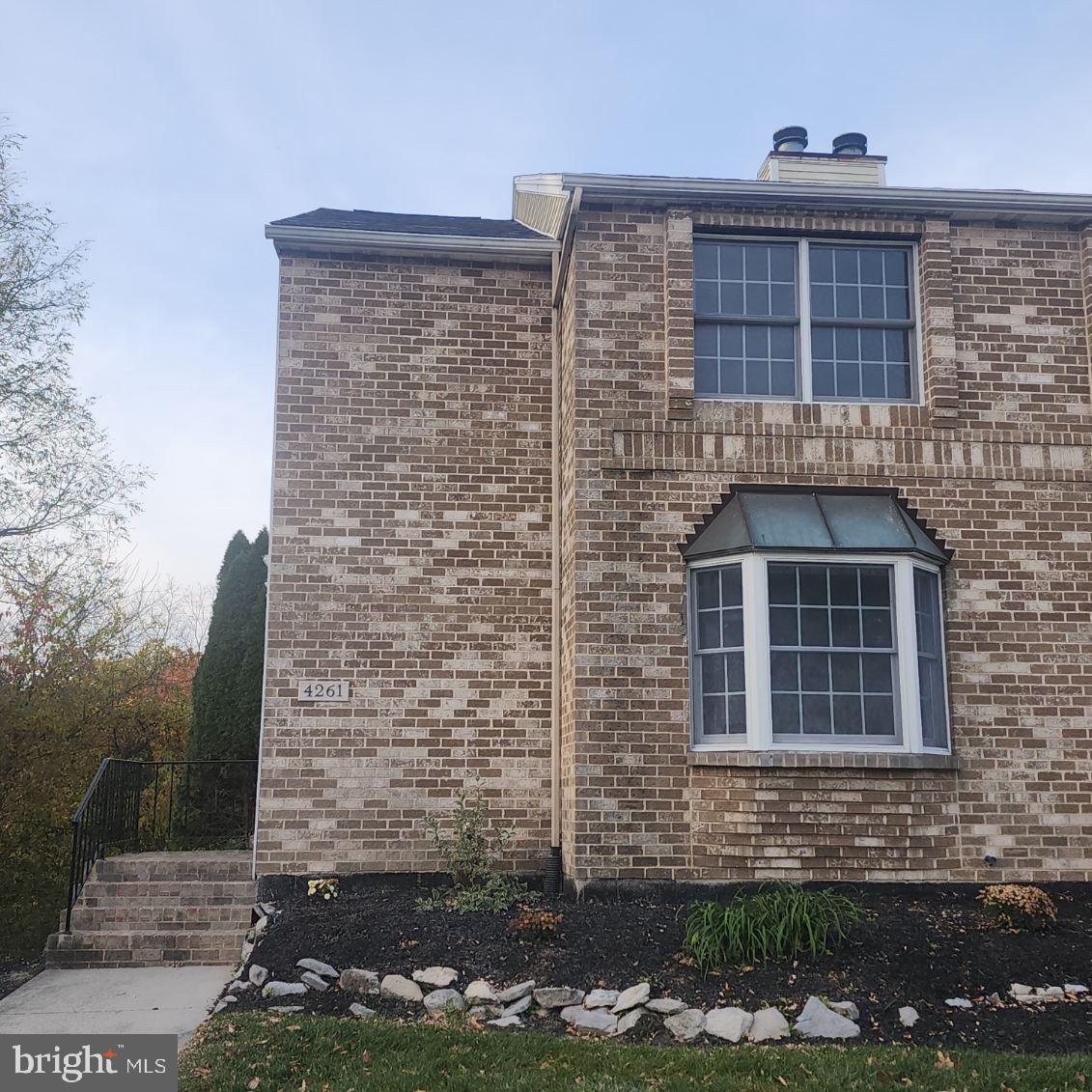 a brick building with a door and a yard