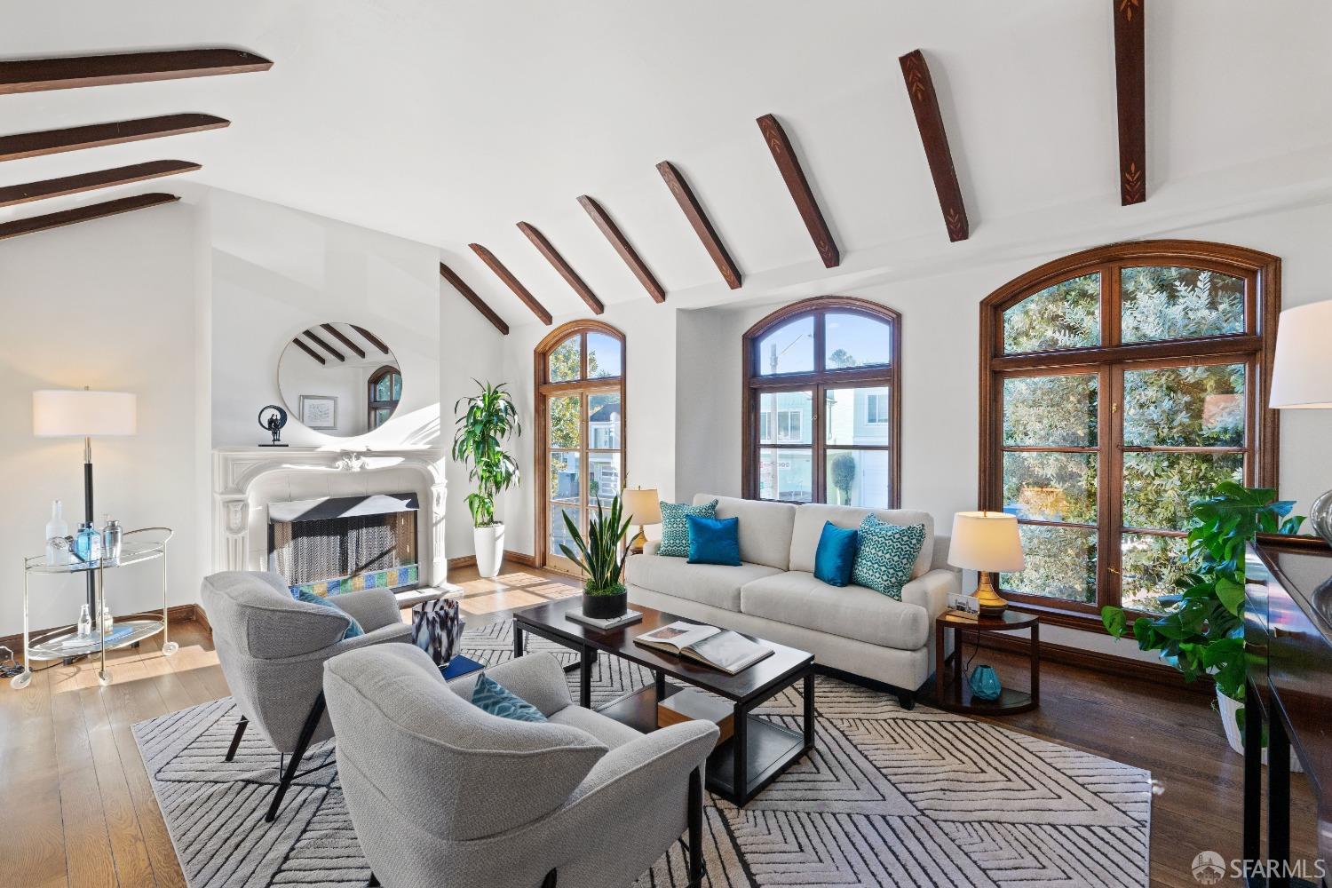 a living room with furniture a fireplace and a chandelier