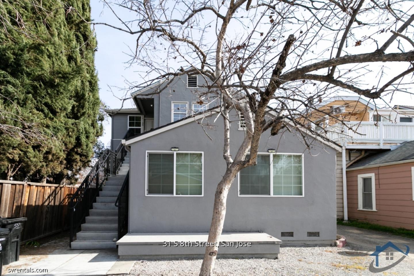 a front view of a house with a tree