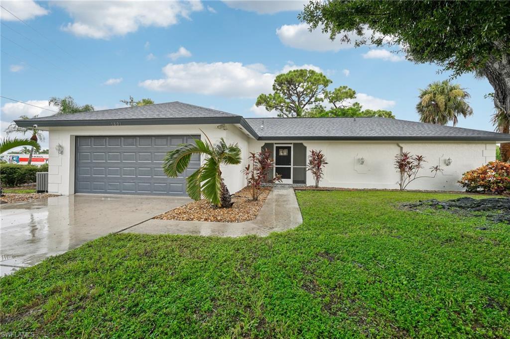 Ranch-style home featuring a garage and a front yard