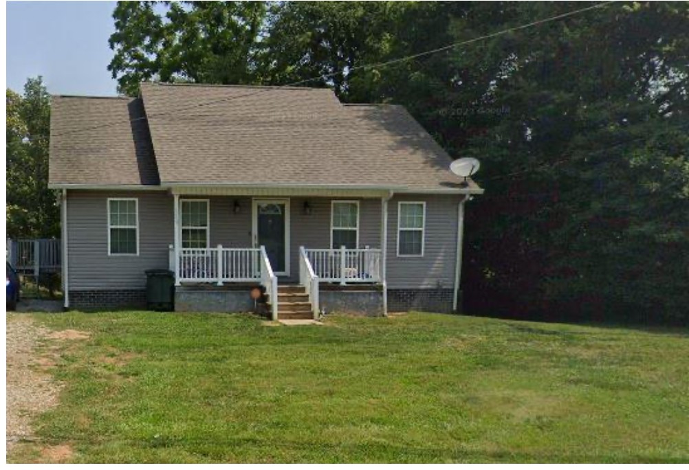 a view of a house with a yard and sitting area