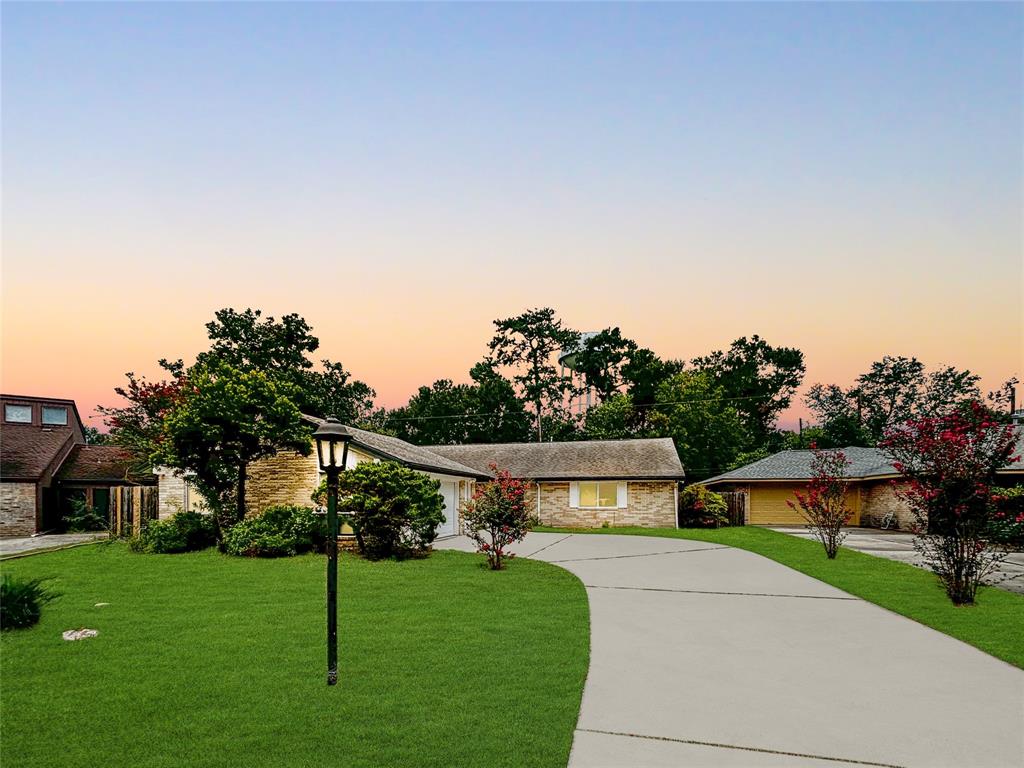 a front view of a house with a yard and tree s