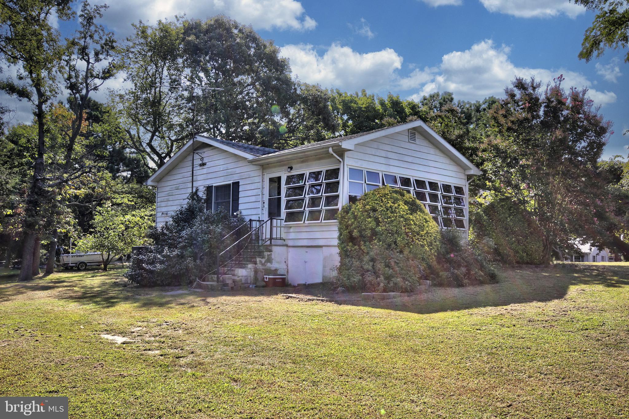 a view of a house with a yard and large tree