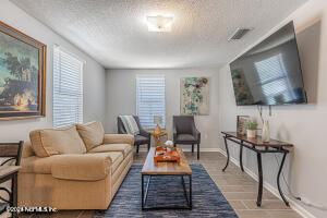 a living room with furniture a flat screen tv and a window