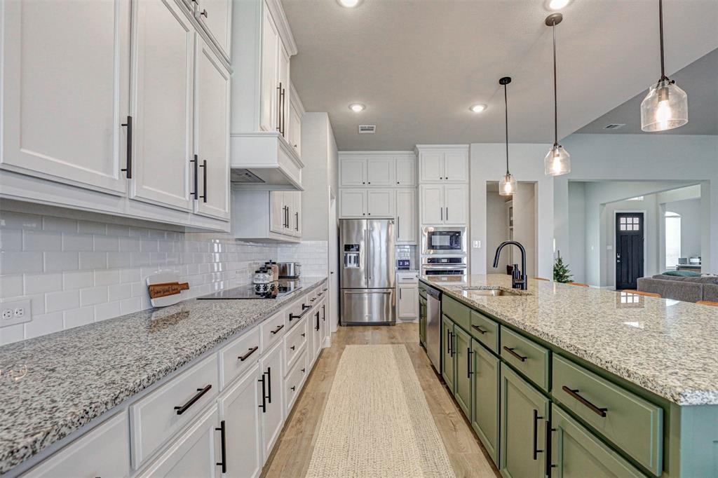 a kitchen with stainless steel appliances granite countertop a sink and cabinets