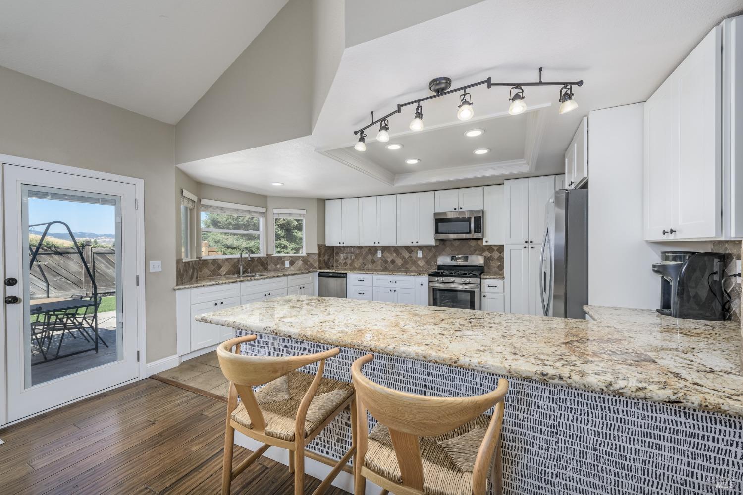 a kitchen with stainless steel appliances granite countertop a stove refrigerator and cabinets