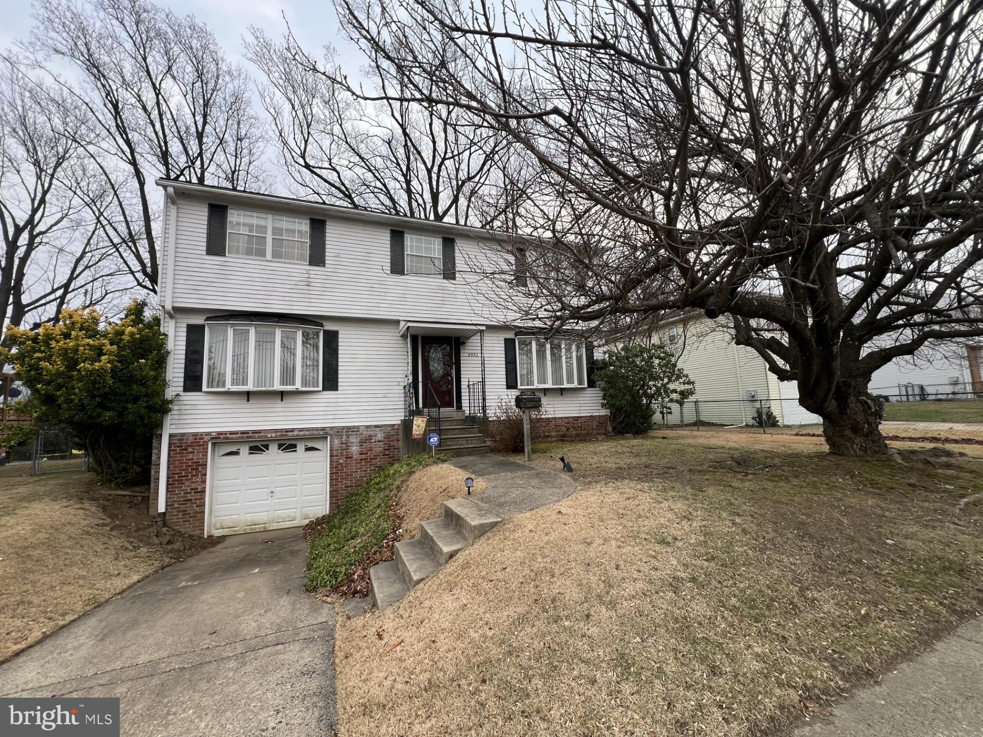 a view of a house with a yard and tree s