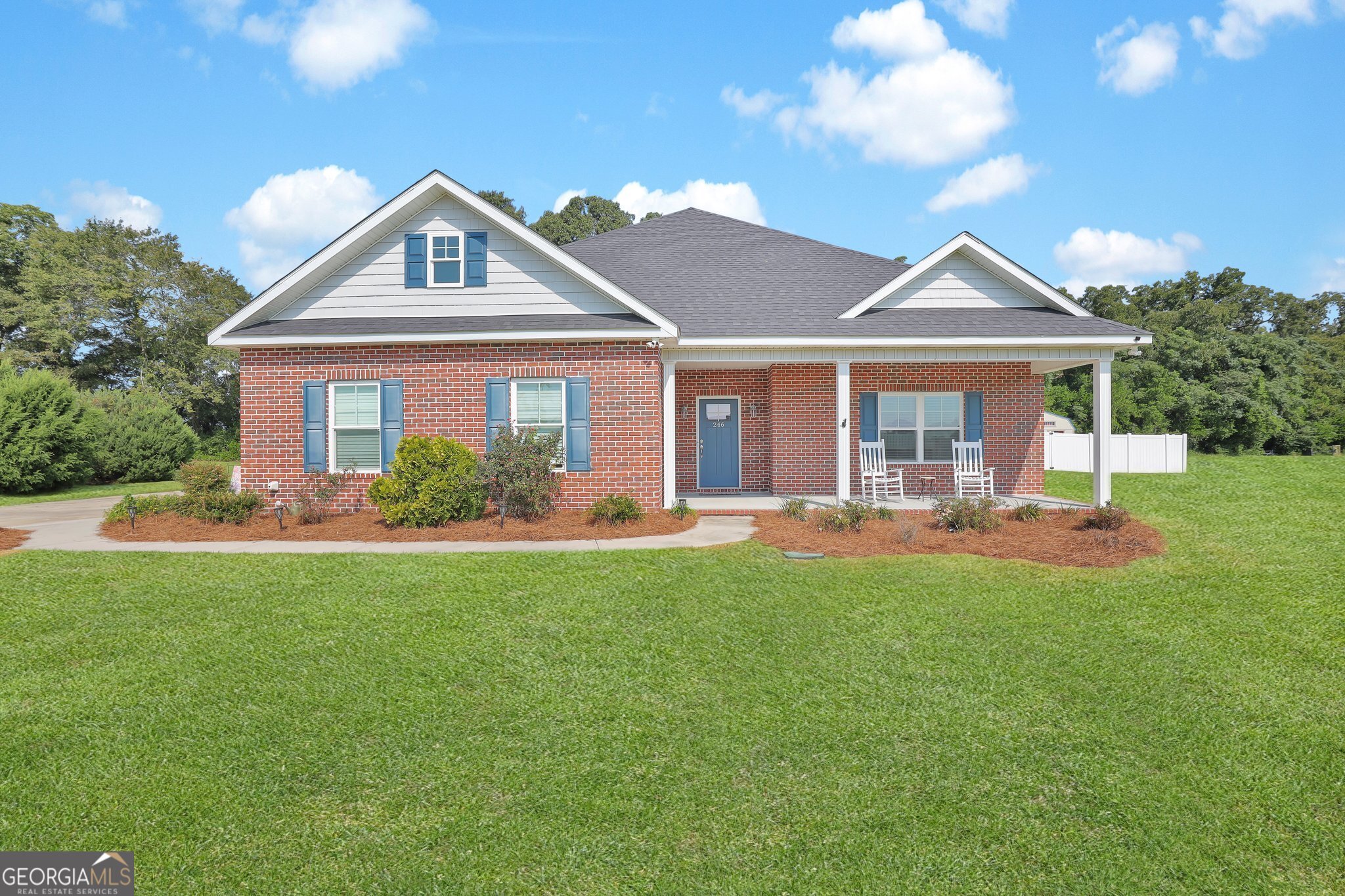 a front view of a house with yard and green space