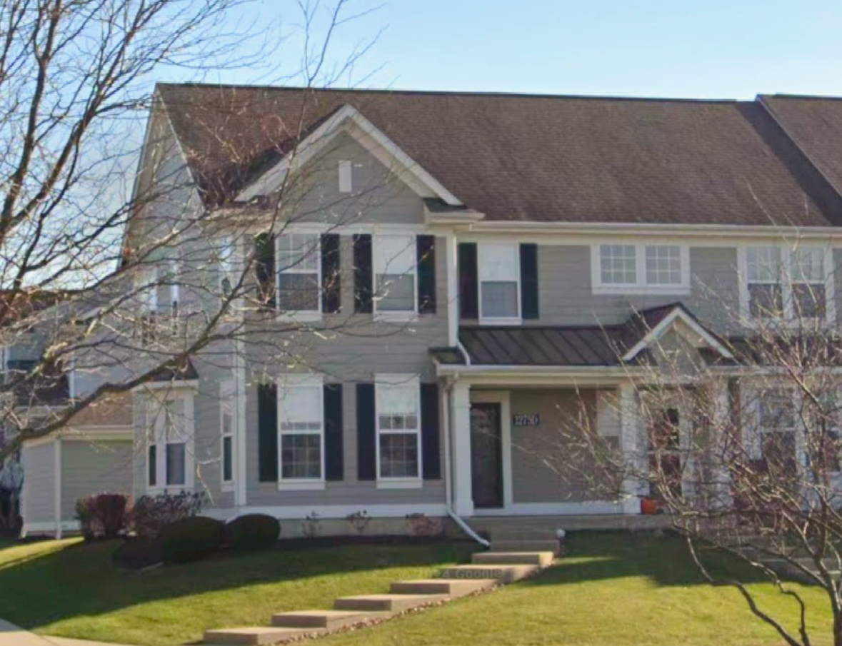 a front view of a house with a large window and a yard