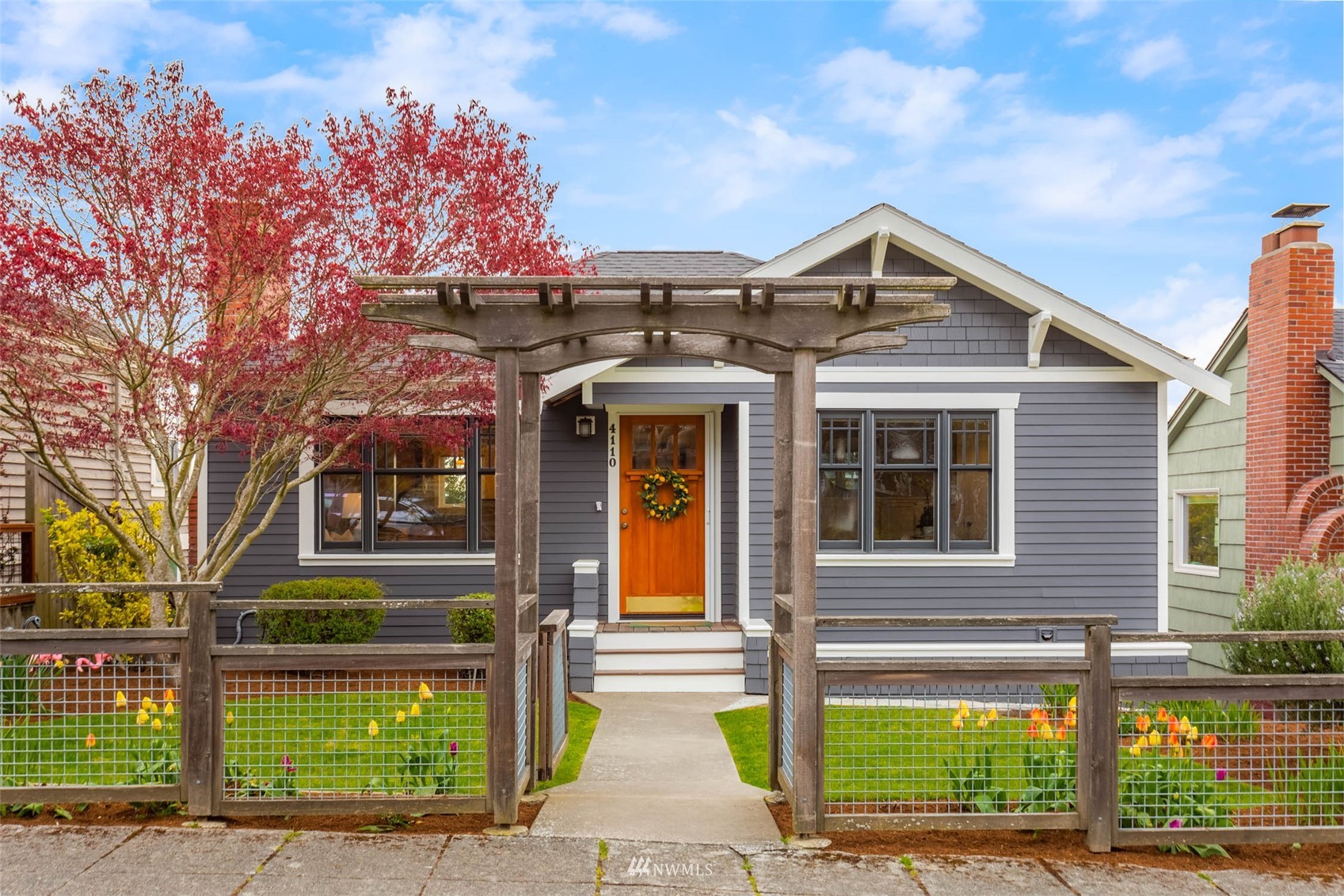 a front view of a house with a garden and plants