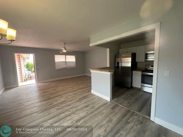 a view of a kitchen with a sink cabinets and wooden floor