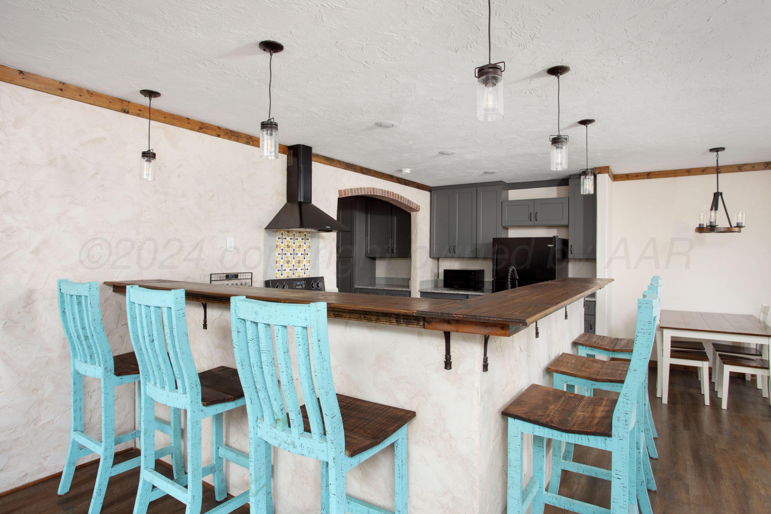 a living room with furniture a flat screen tv and kitchen view