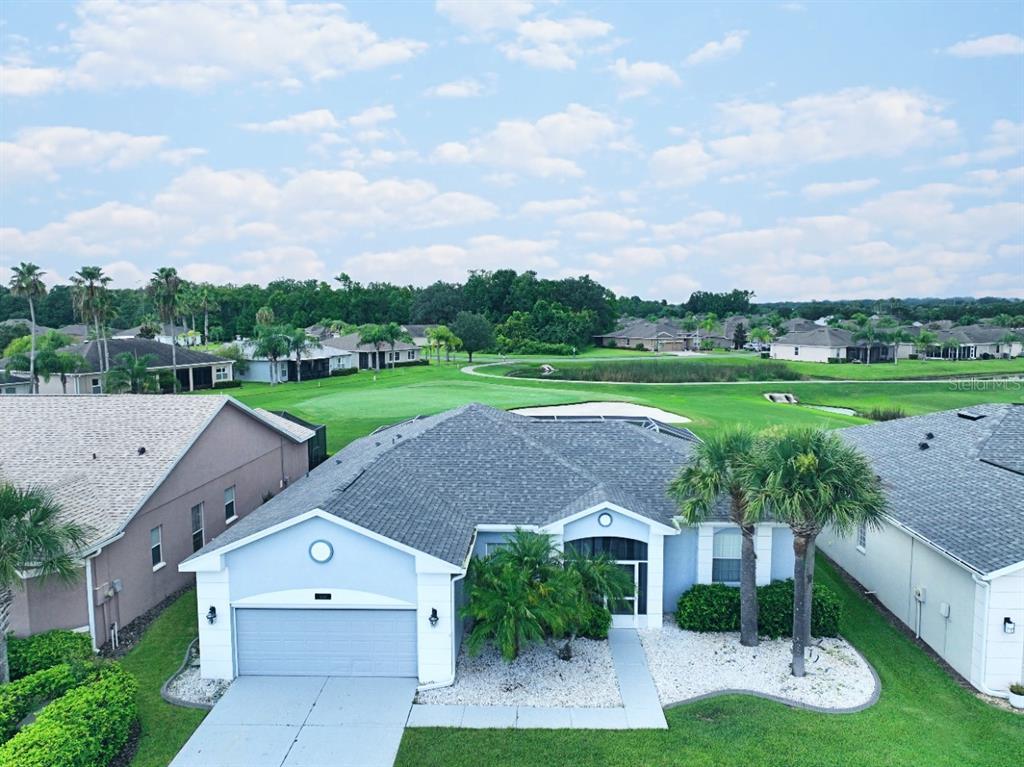 an aerial view of a house with a yard and trees