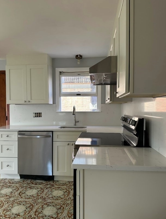 a kitchen with a sink a stove and cabinets