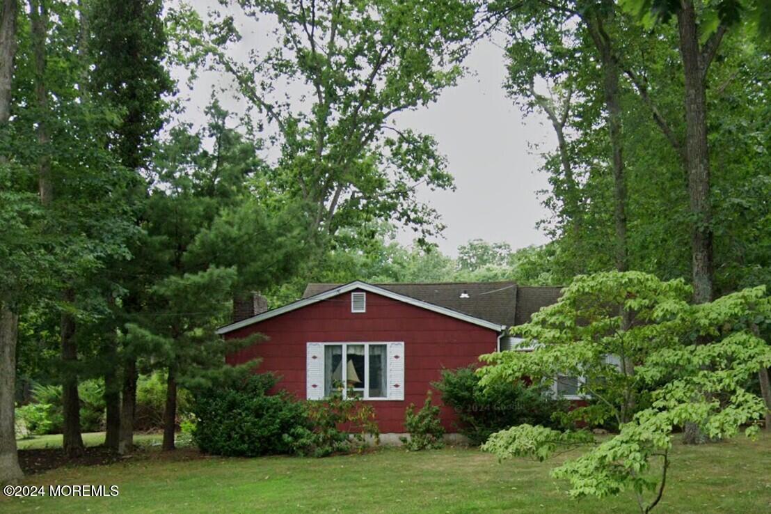 a front view of a house with a yard and green space