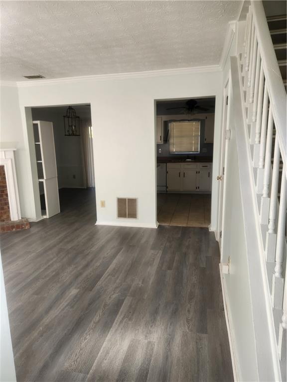 a view of a hallway with wooden floor and a living room