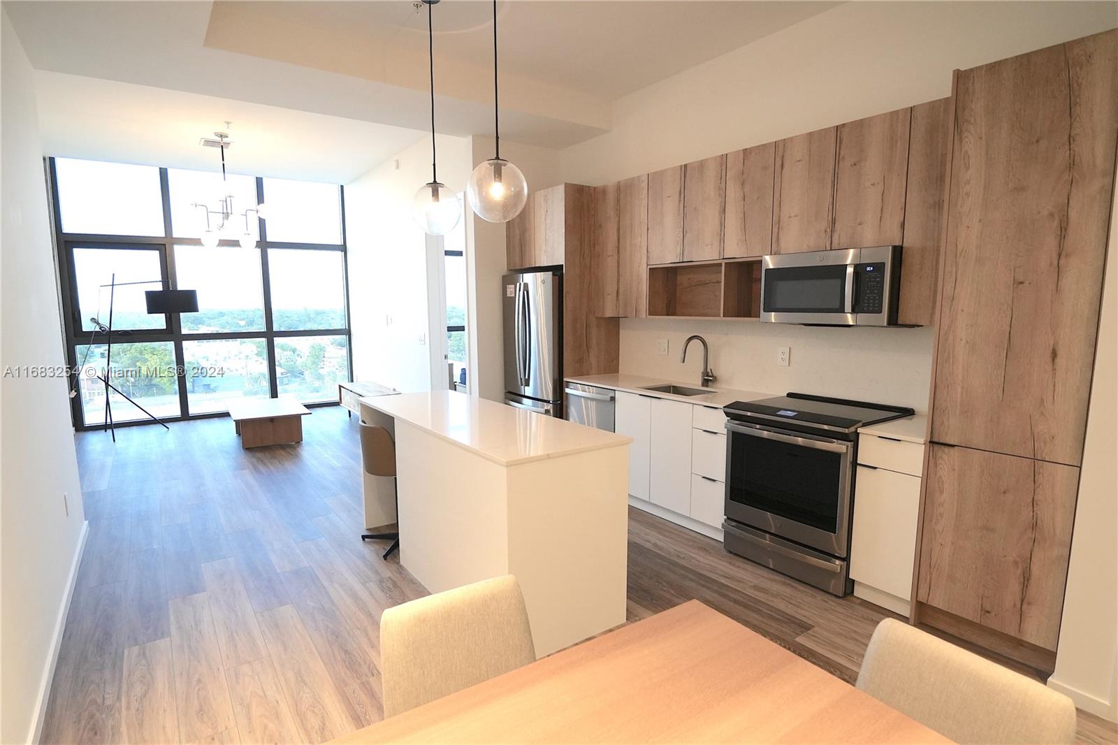 a kitchen with kitchen island granite countertop wooden floors and stainless steel appliances