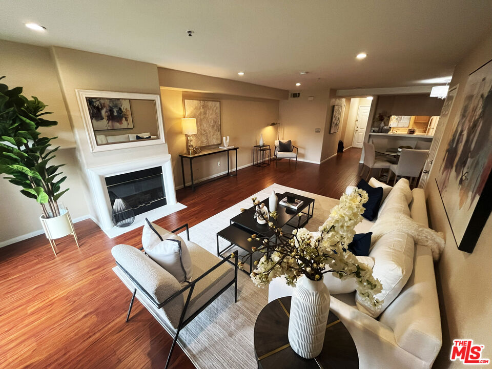 a living room with furniture kitchen view and a fireplace