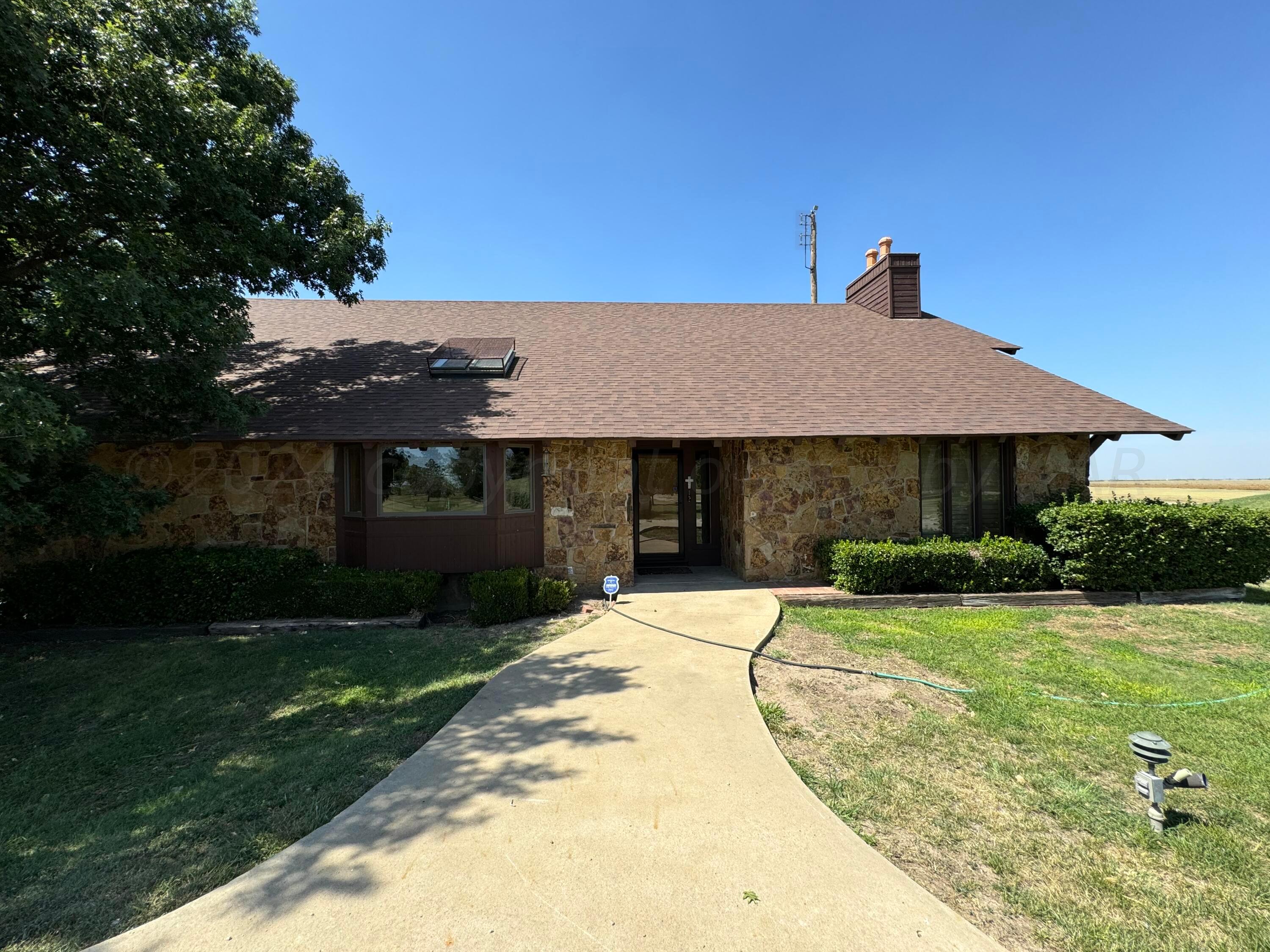 a front view of a house with a garden and yard