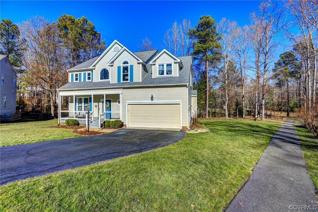 a view of a house with a yard and large tree