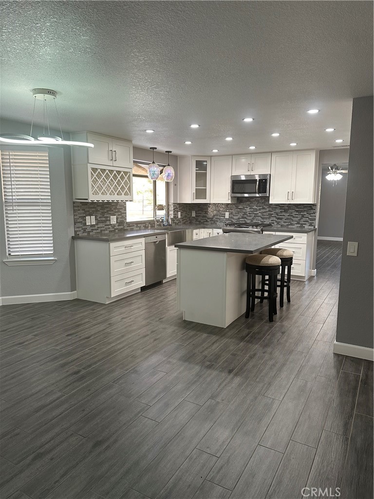 a kitchen with a kitchen island hardwood floor sink stove dining table and chairs