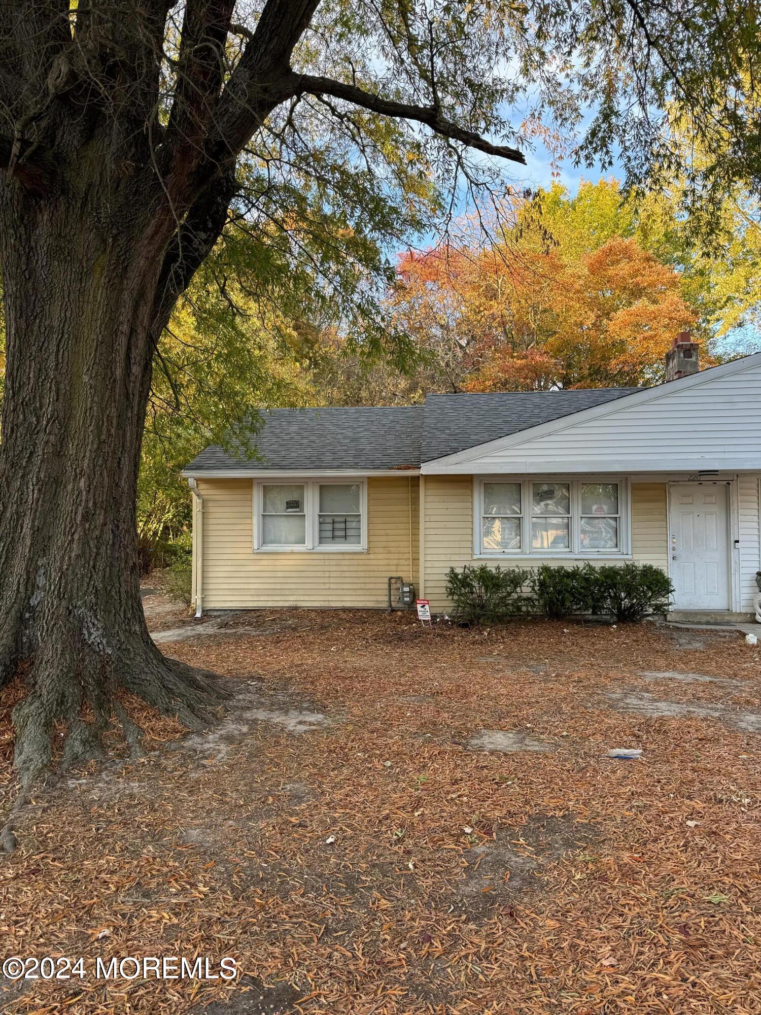 a front view of house with yard and trees in the background