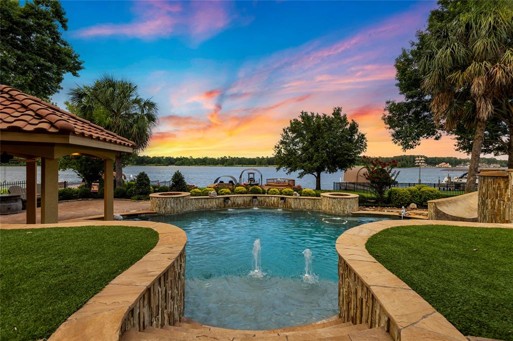 a view of a swimming pool and lounge chairs in back yard