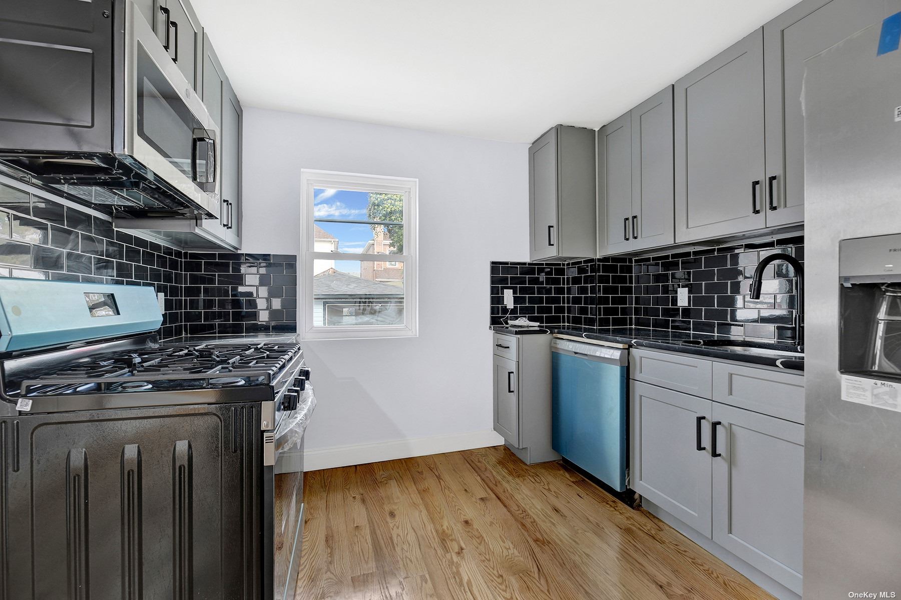 a kitchen with stainless steel appliances a stove a sink and cabinets