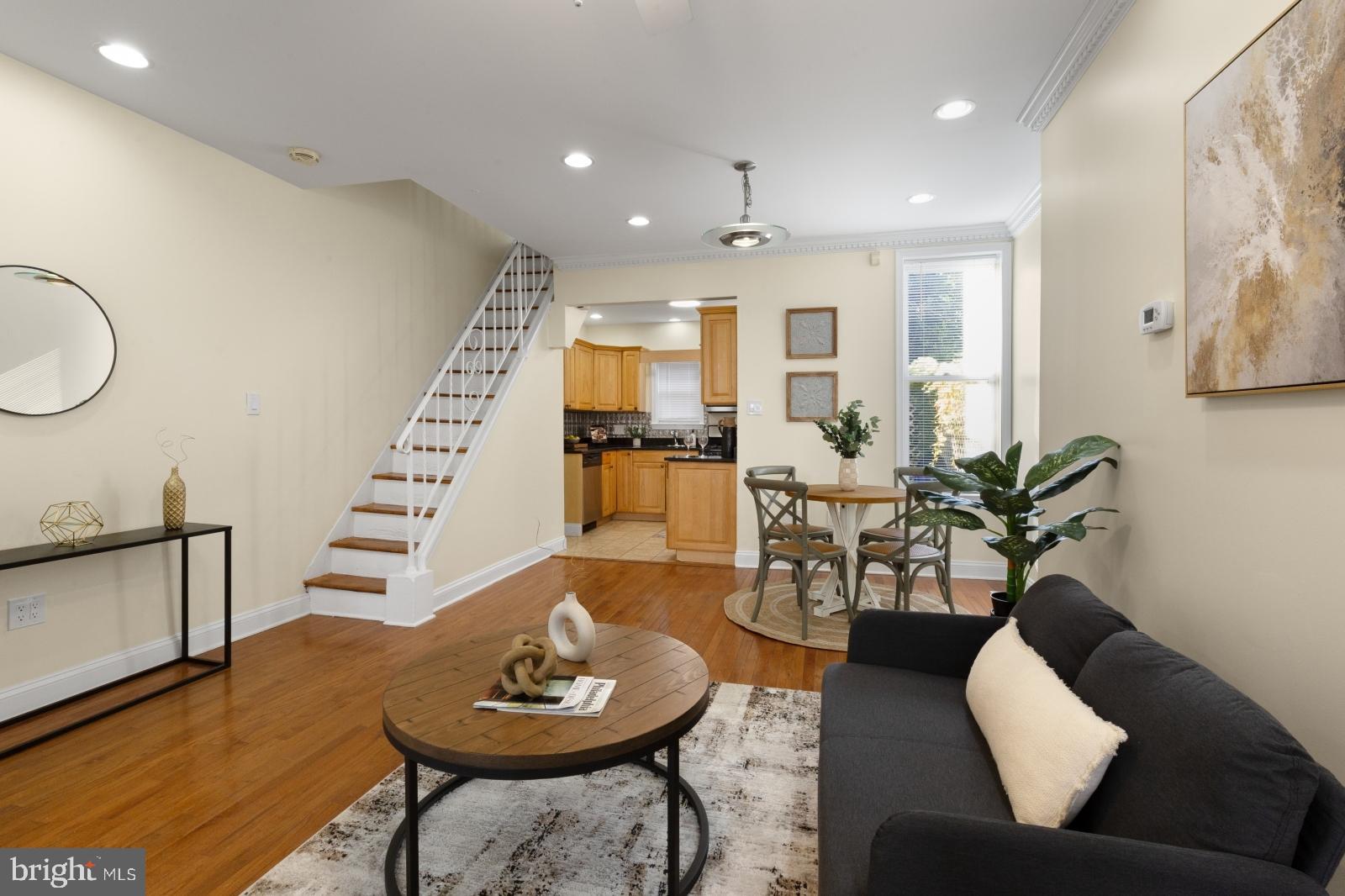 a living room with furniture and a wooden floor