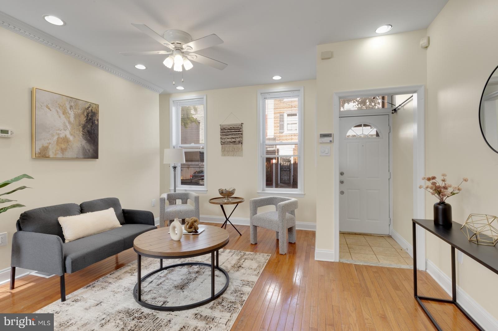 a living room with furniture a table and wooden floor