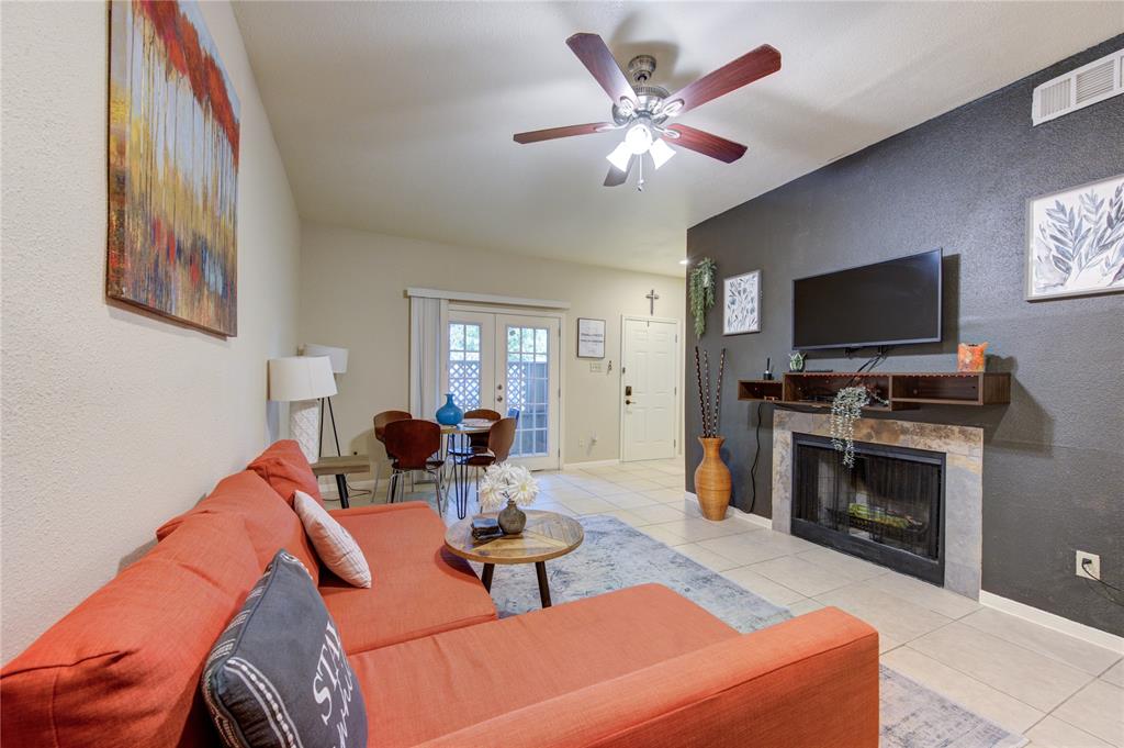 a living room with furniture a fireplace and a flat screen tv