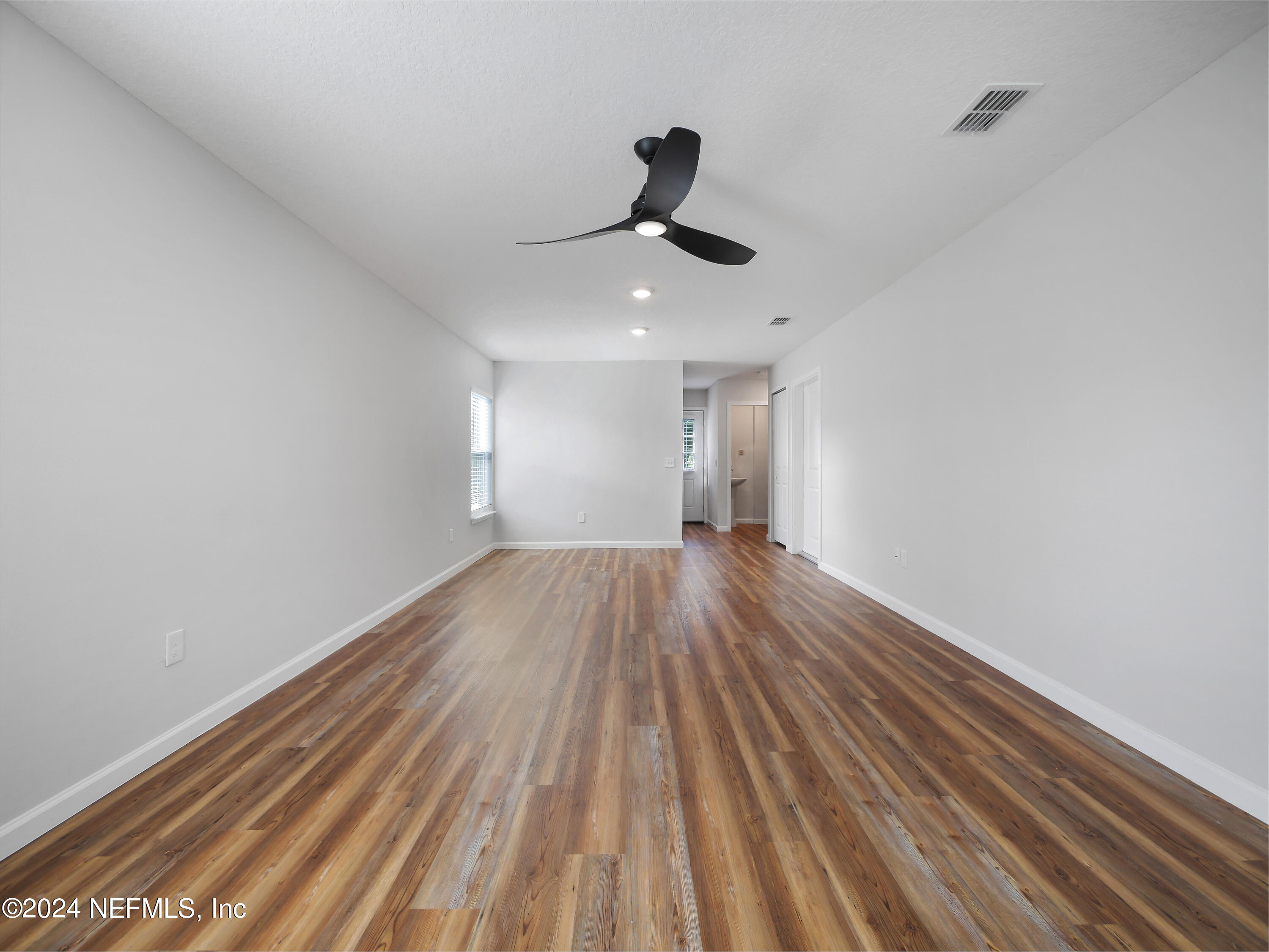 a view of empty room with wooden floor